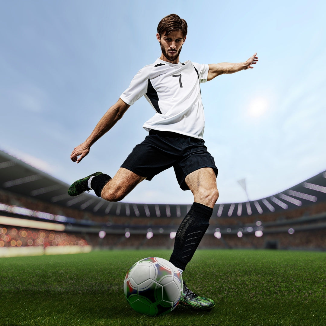 Soccer player in action on a field with stadium in the background